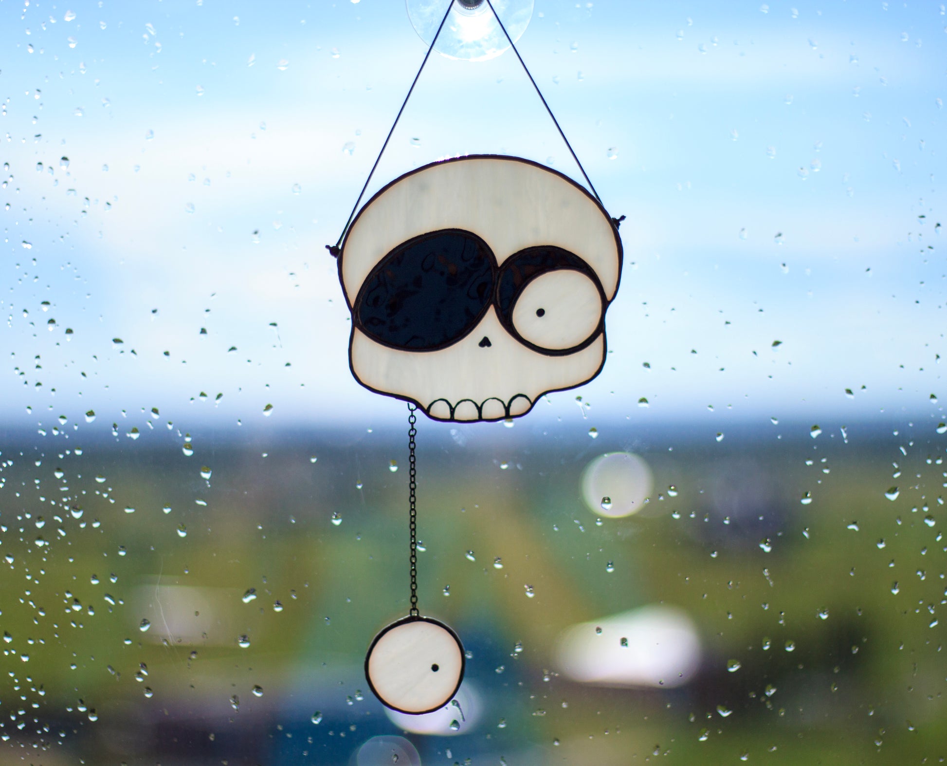 Droopy eye skull stained glass suncatcher — 12.2×6.7 inch vertical window art, dark halloween aesthetic, made in Ukraine