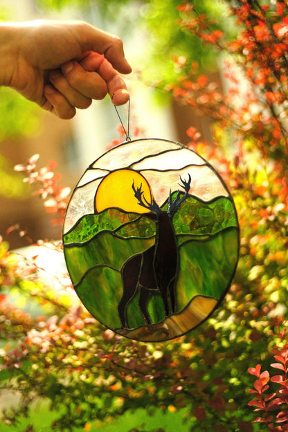 Round deer landscape stained glass panel hanging in window — amber sunset light catcher, cabin nature decor