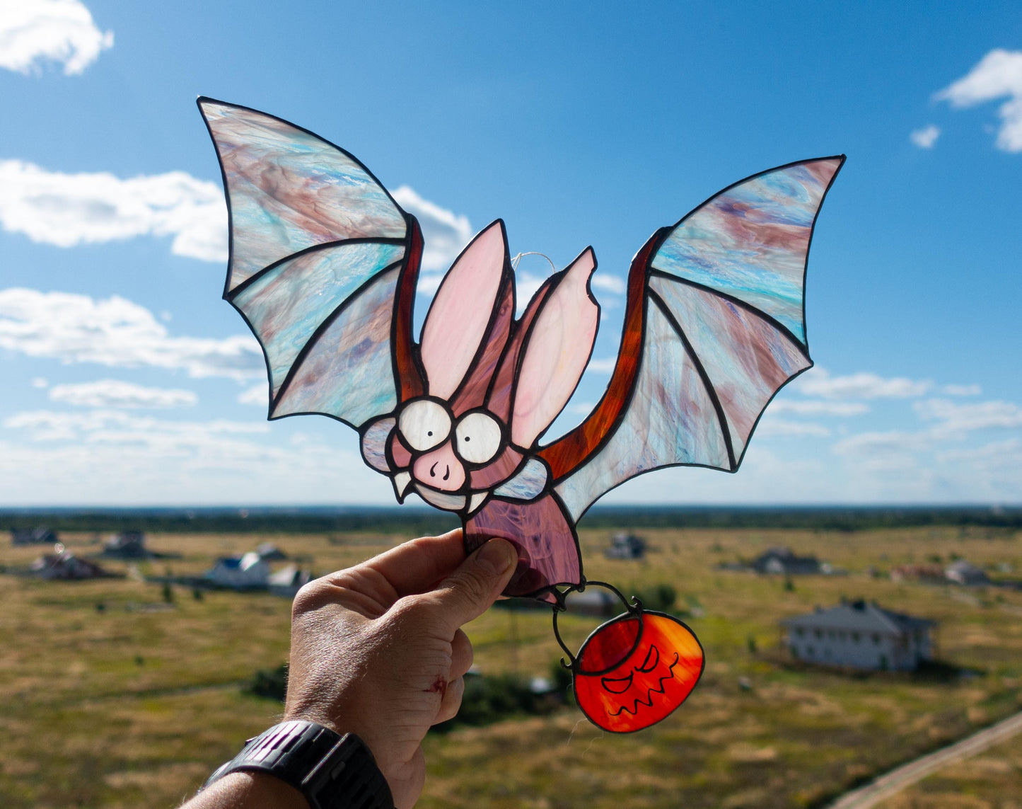Handmade stained glass Halloween bat with pumpkin suncatcher — spooky window art, Mojoartglass


