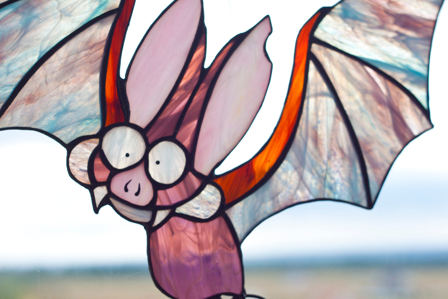 Halloween stained glass suncatcher hanging in window — 280×300mm, bat and pumpkin design

