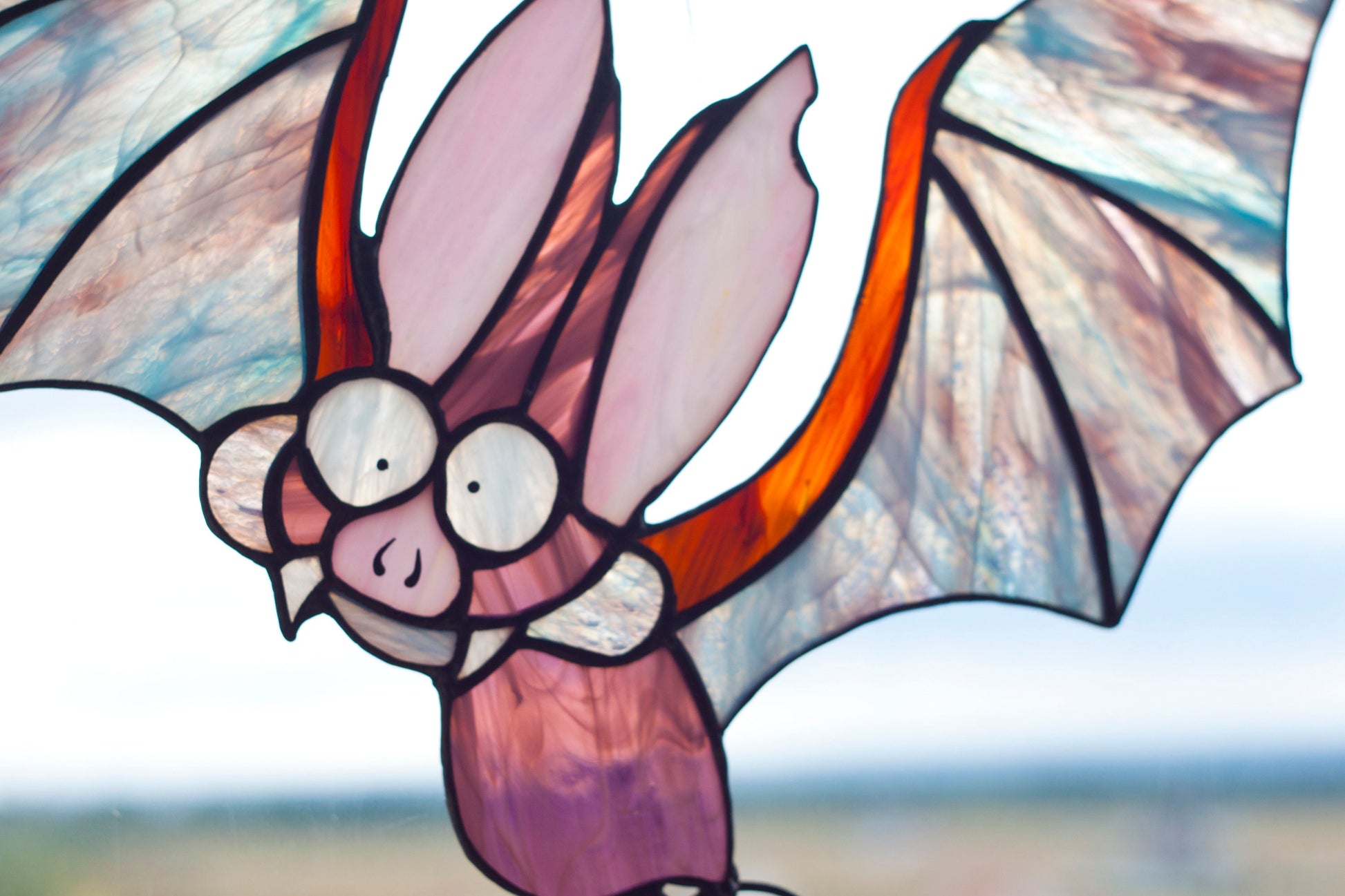 Halloween stained glass suncatcher hanging in window — 280×300mm, bat and pumpkin design

