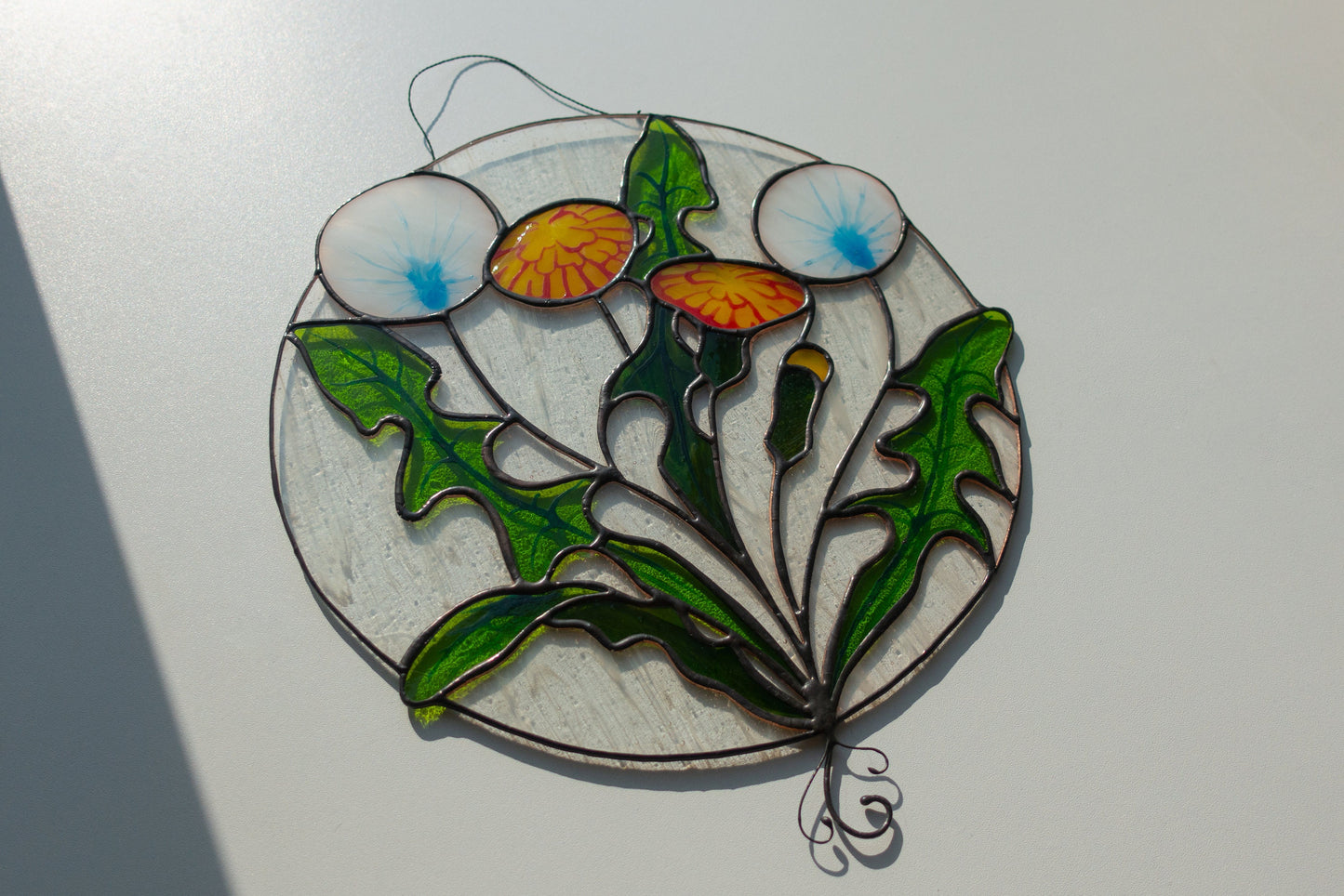 Round stained glass dandelion close-up — black patina finish, individual seed filaments hand-cut