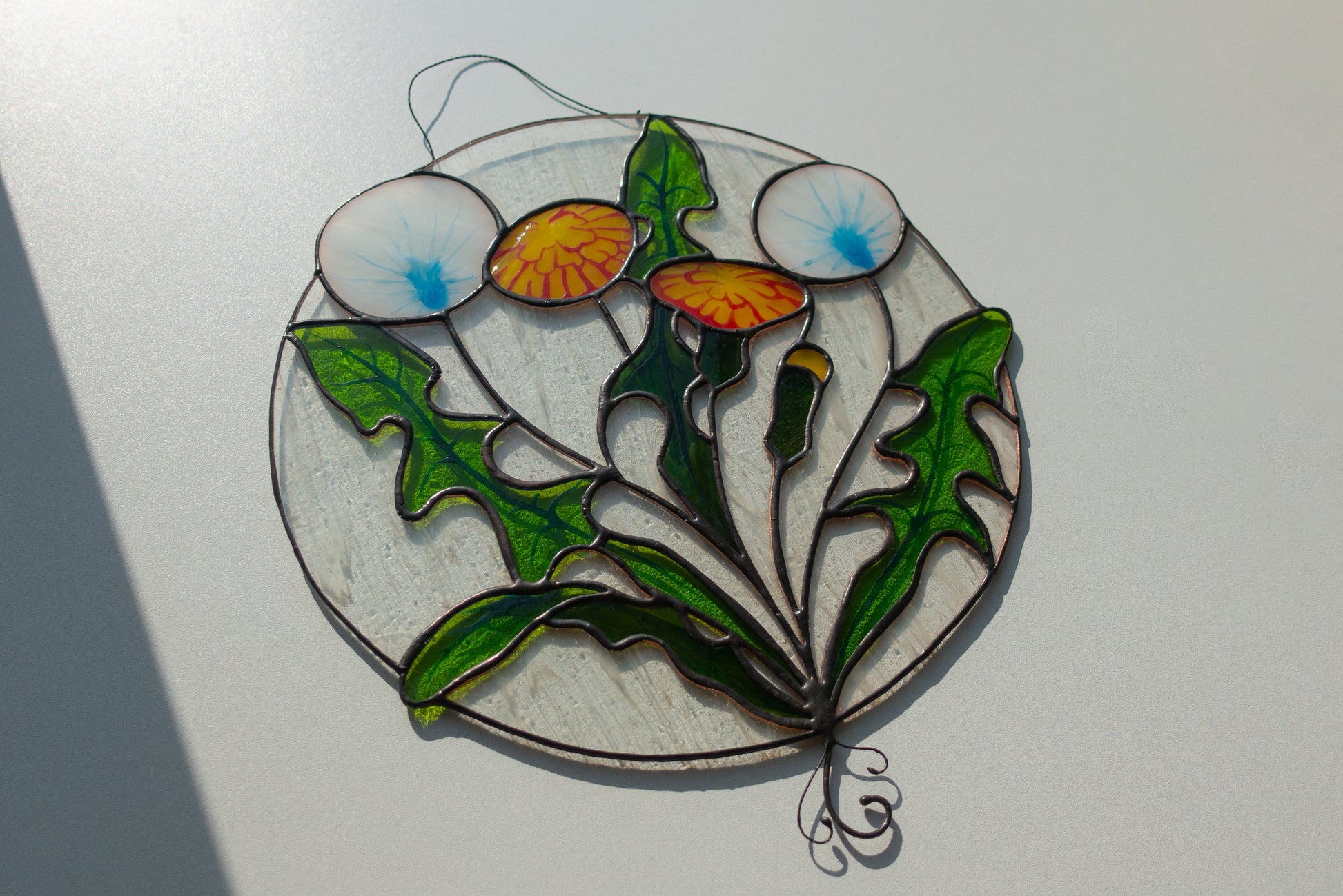 Round stained glass dandelion close-up — black patina finish, individual seed filaments hand-cut