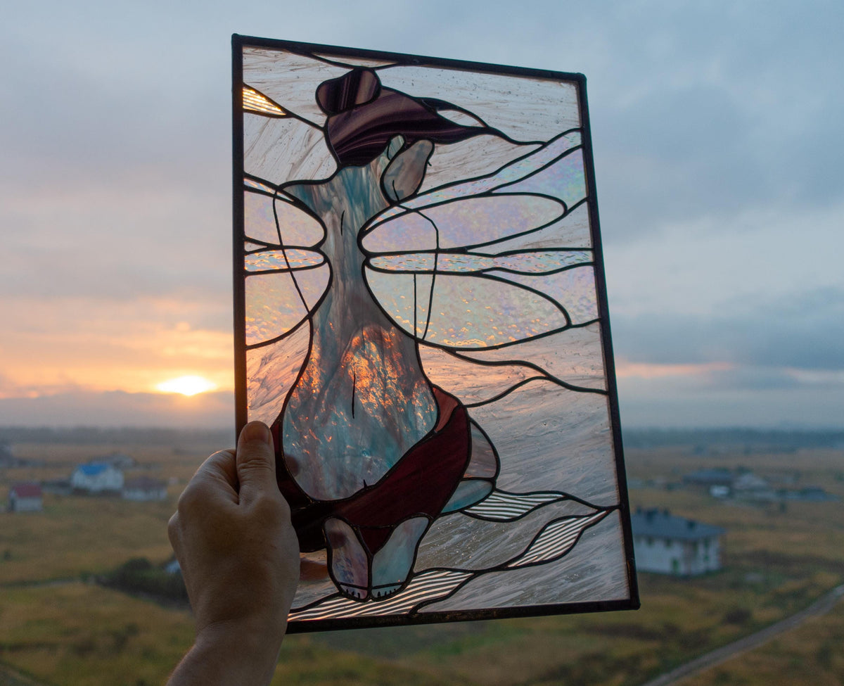 Handmade stained glass fairy girl panel held up against sunset sky, iridescent wings with burgundy dress, graceful feminine figure, Tiffany copper foil technique