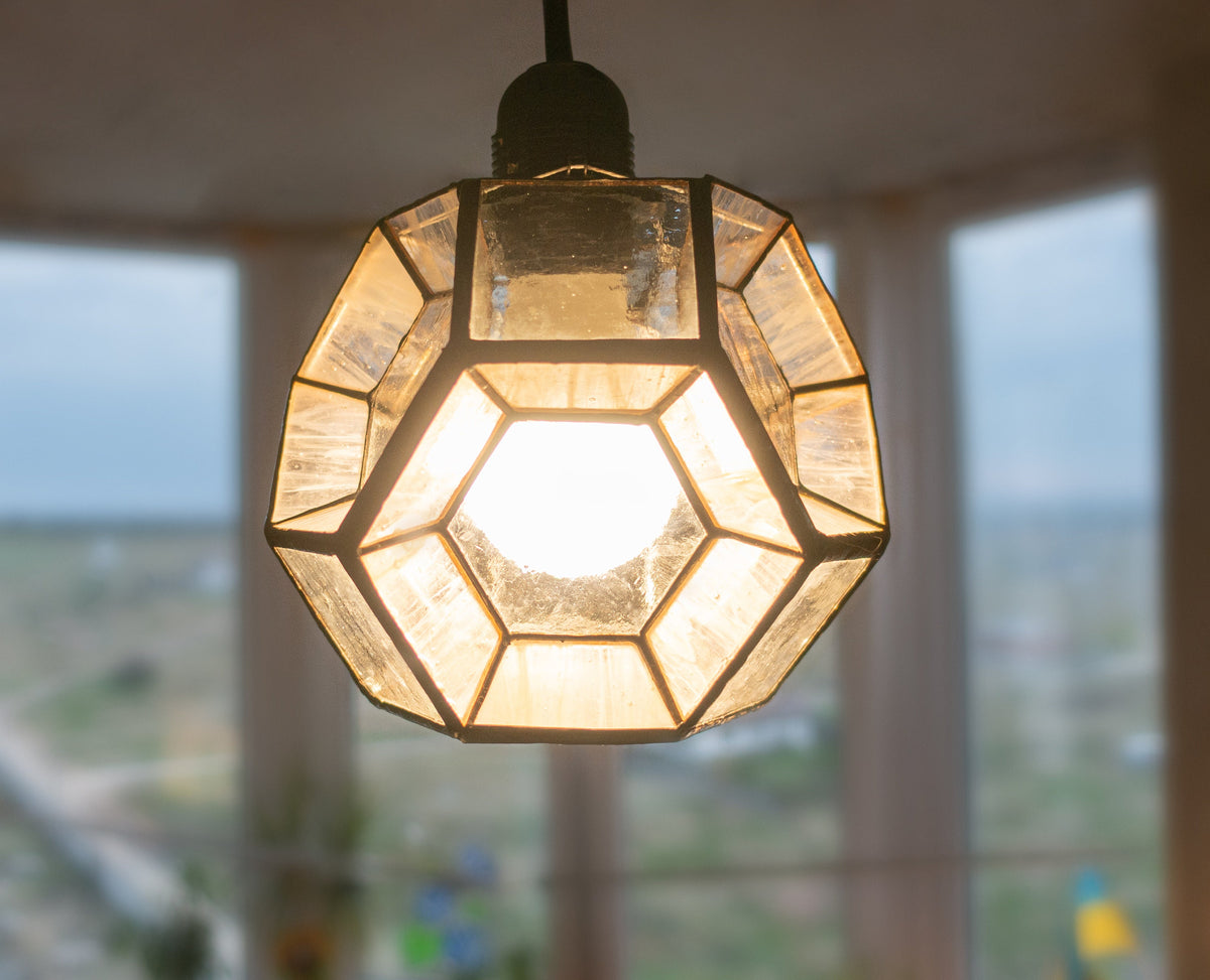 Stained glass hexagon lamp parts in production on work table, clear glass panels with copper foil before assembly, handmade in Ukraine