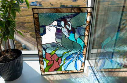 Stained glass mermaid and manta ray panel on windowsill with plant in sunlight, teal and blue ocean glass with red coral and green seaweed, Tiffany copper foil