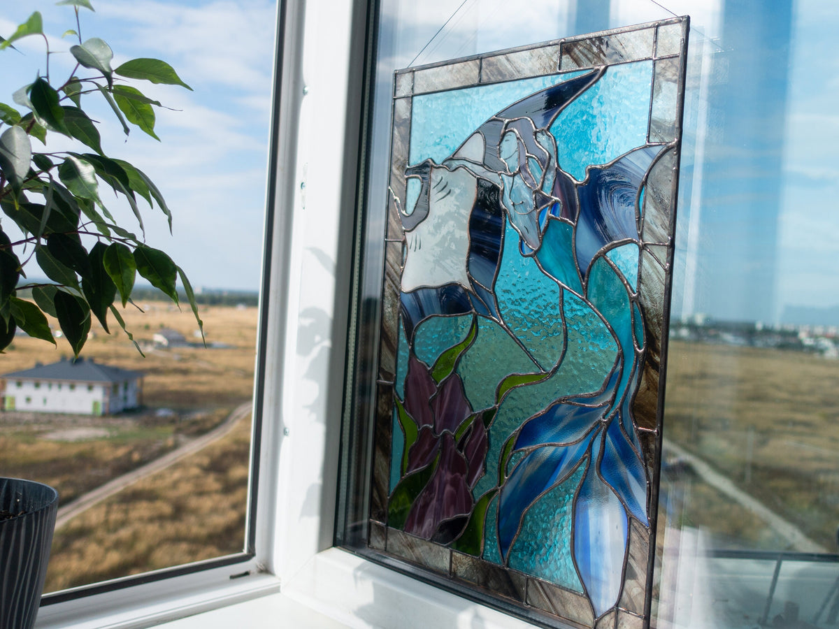 Stained glass mermaid and stingray panel hanging in window with plant, turquoise ocean glass with blue mermaid tail and purple seaweed, ocean fantasy window art