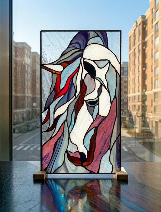 Handmade stained glass mustang horse panel displayed on a wooden stand against a city window, copper foil Tiffany method, blue and red mane