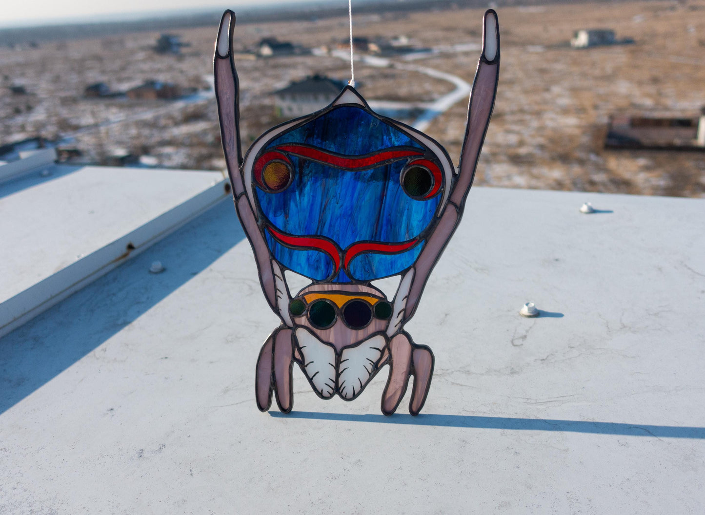 Handmade iridescent stained glass peacock jumping spider suncatcher — colorful bug window art, Mojoartglass

