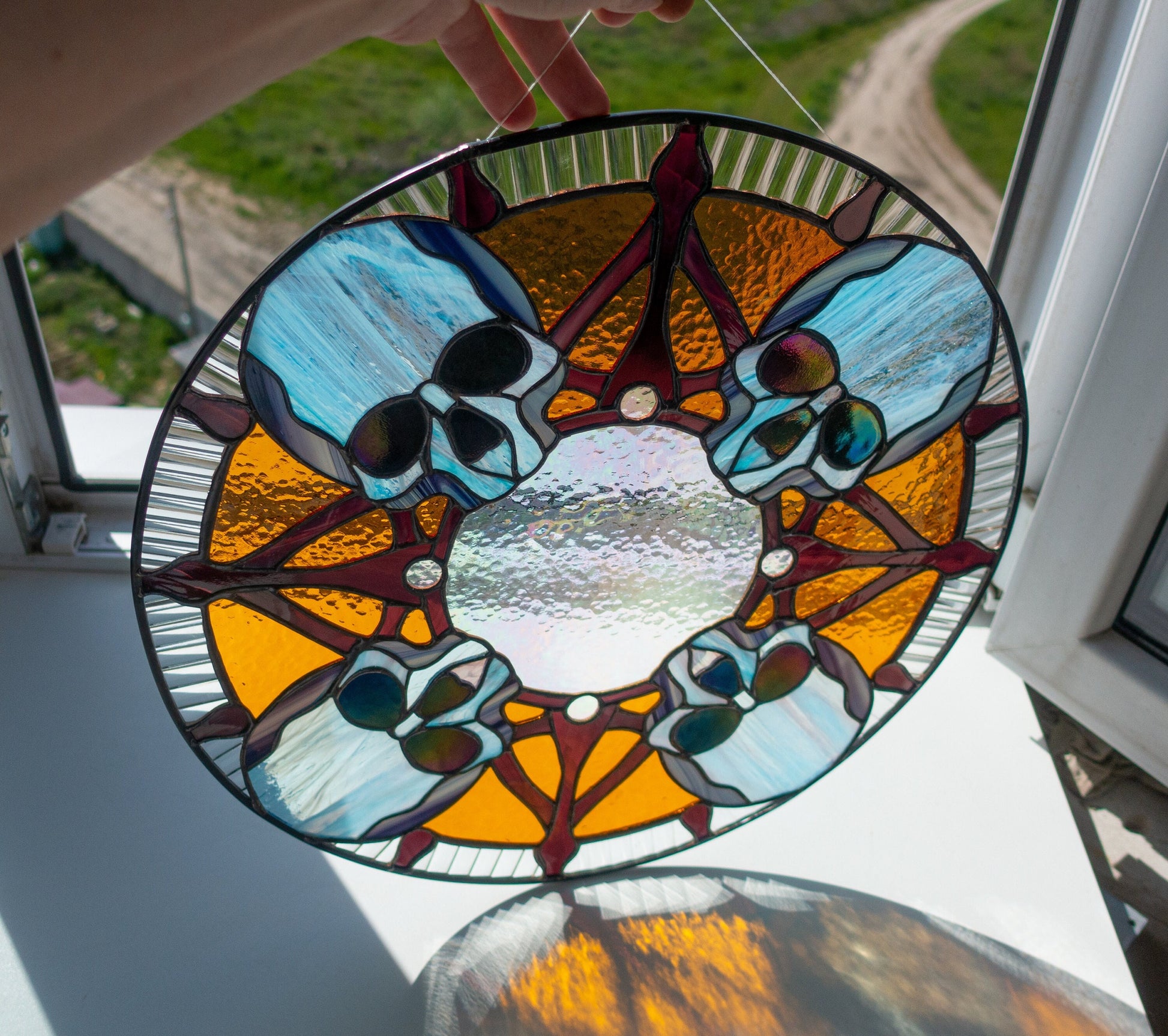 Halloween skull round stained glass — dark mysterious colors, bold bone detail in circular composition, made in Ukraine