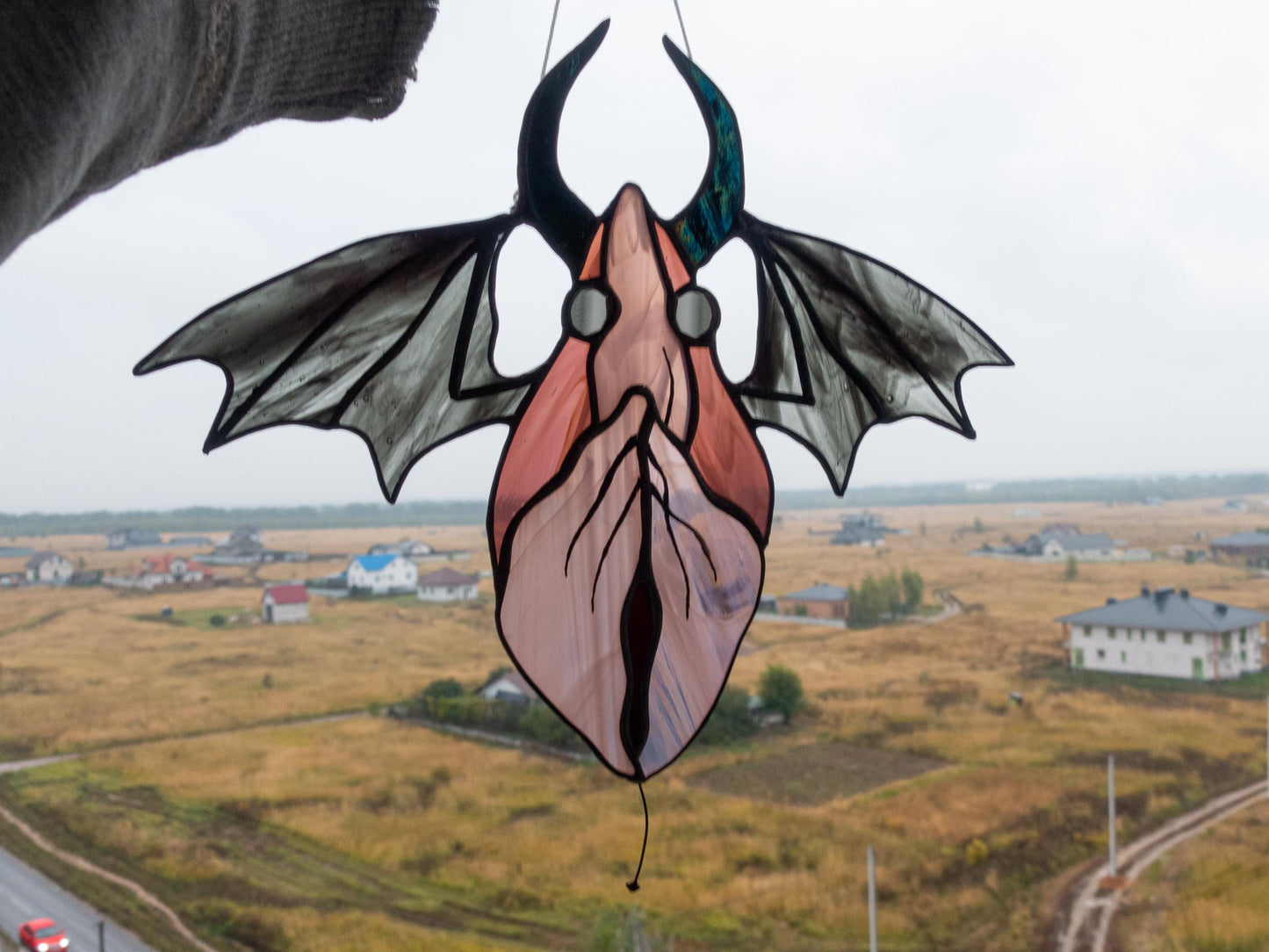Mythic winged spirit suncatcher hanging in window — gothic light catcher, dark fantasy feminine art